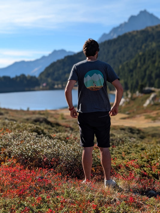 The Geislers men's t-shirt with large back print, worn on an autumn hike by an alpine lake