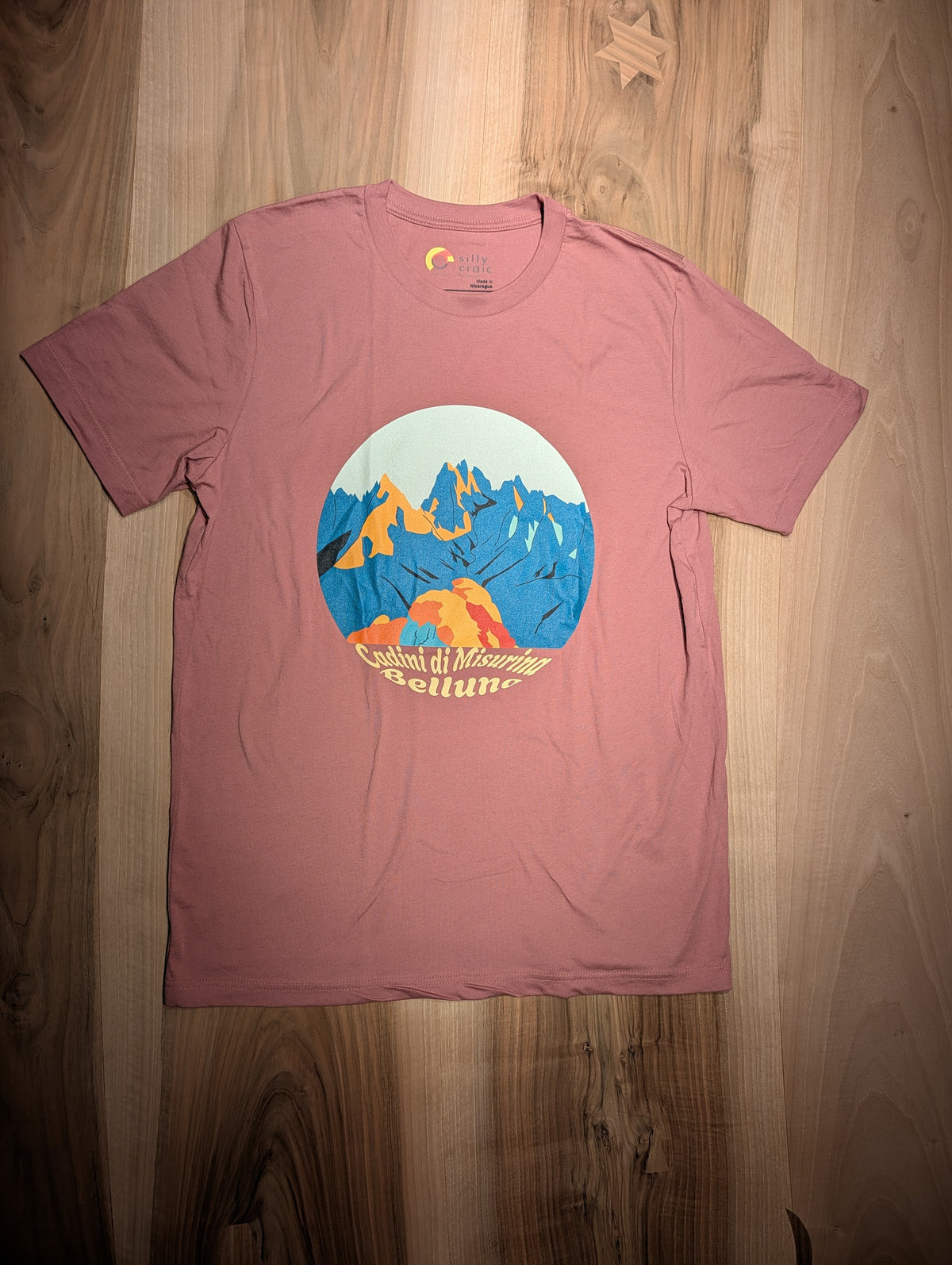 Cadini di Misurina t-shirt, flat lay on wood – close-up of the Dolomite spires design