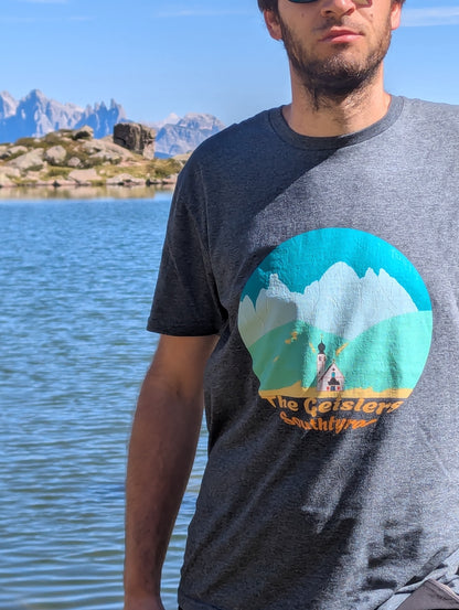 The Geislers men's t-shirt in dark heather worn at an alpine lake in the Dolomites – Silly Craic