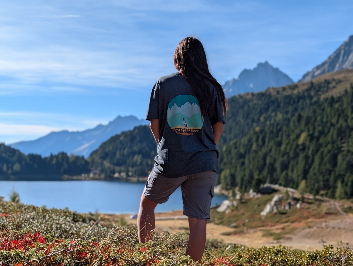 The Geislers t-shirt with large back print, worn oversized by her on an autumn hike by an alpine lake