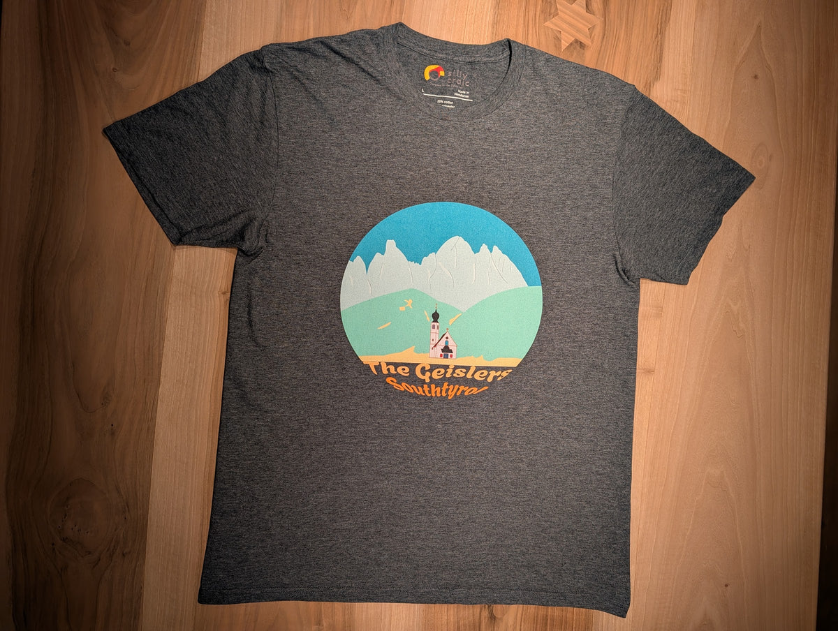 The Geislers t-shirt in dark heather, flat lay on wood – close-up of the Geisler Peaks design