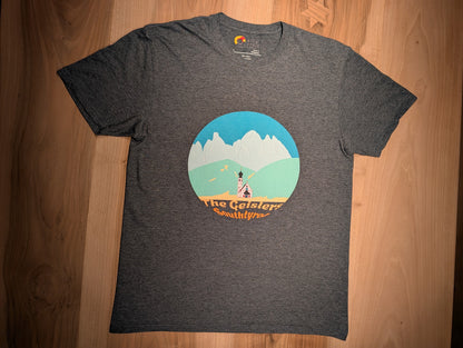 The Geislers t-shirt in dark heather, flat lay on wood – close-up of the Geisler Peaks design