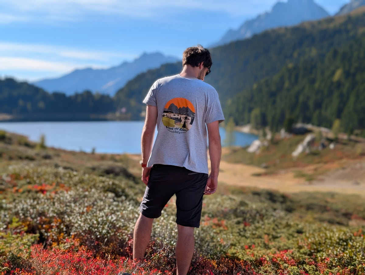 Alpe di Siusi men's t-shirt with large back print, worn on an autumn hike by an alpine lake