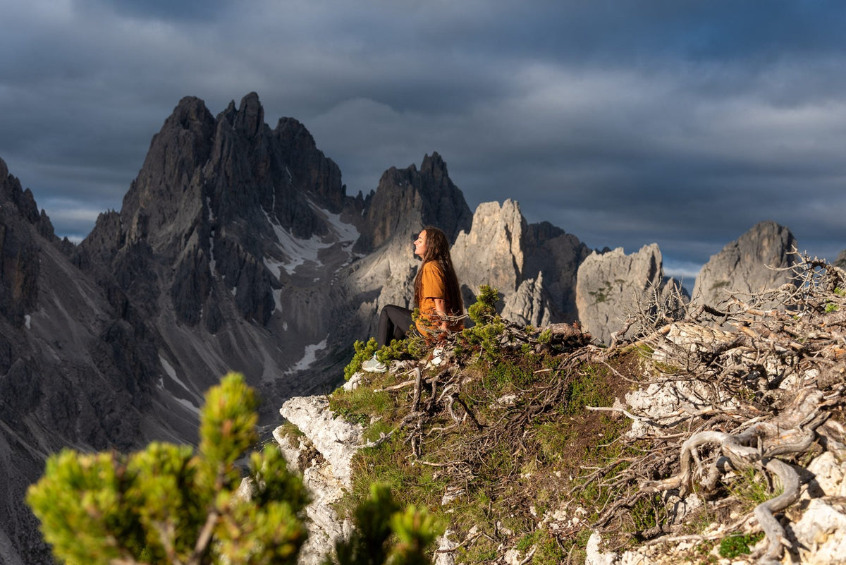 Hiker enjoying the view of the jagged Cadini di Misurina spires in the Dolomites, Italy